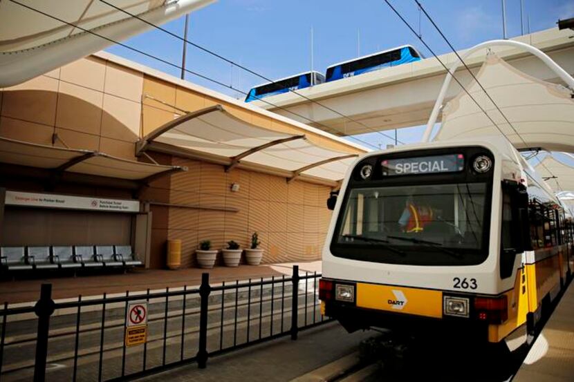 
A DFW Skylink train moves overhead at the new Dallas Area Rapid Transit Orange Line stop at...