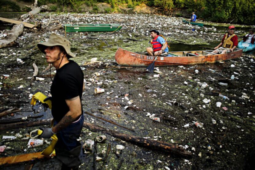 Canoers and kayakers seemed to float on a trash pile Saturday during the White Rock Creek...