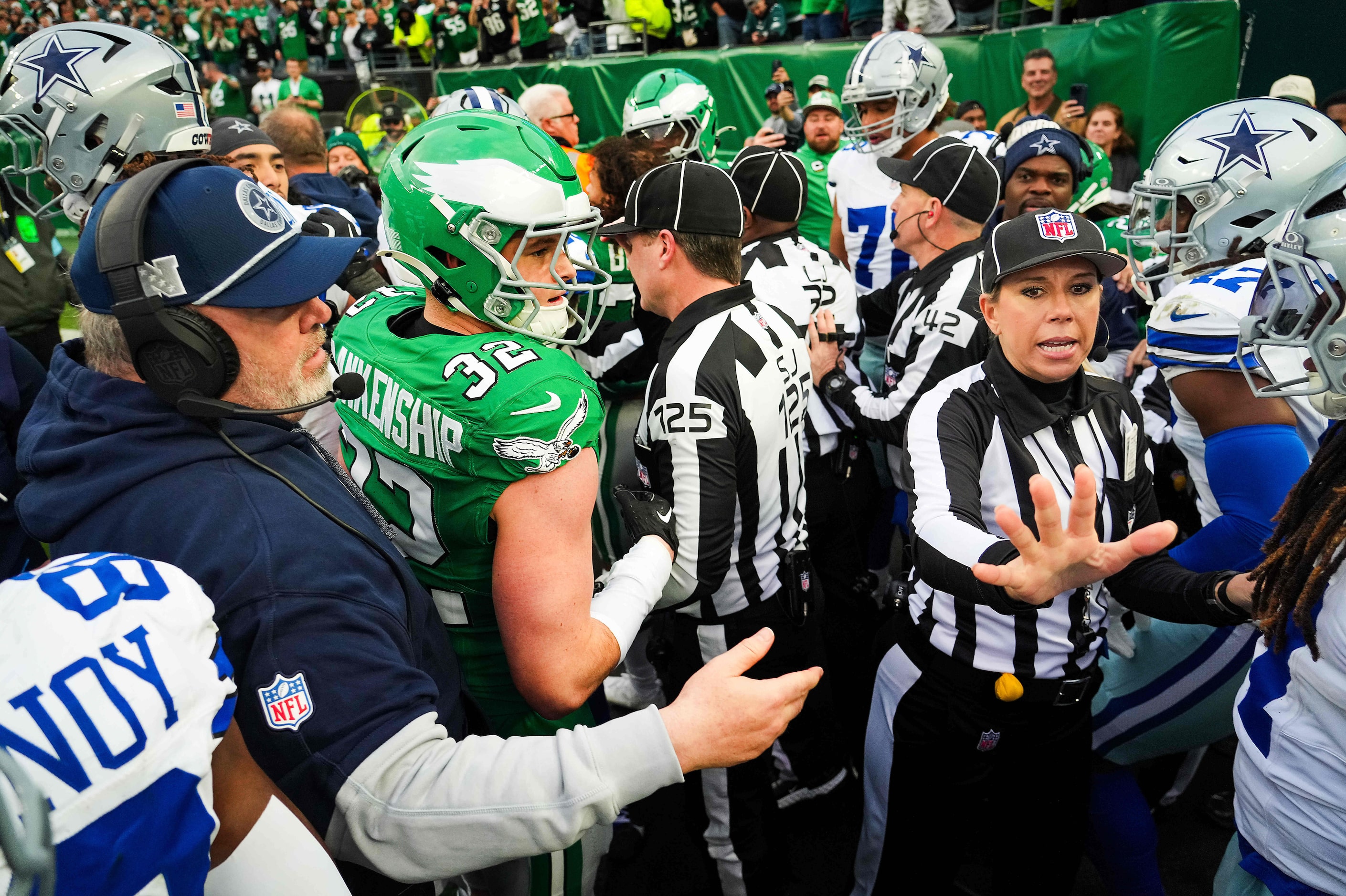 Dallas Cowboys head coach Mike McCarthy and down judge Sarah Thomas try to separate players...