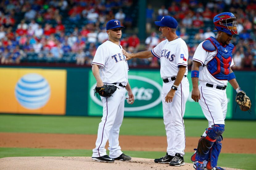 Texas Rangers starting pitcher Wandy Rodriguez (51) is talked to b by Mike Maddux, pitching...