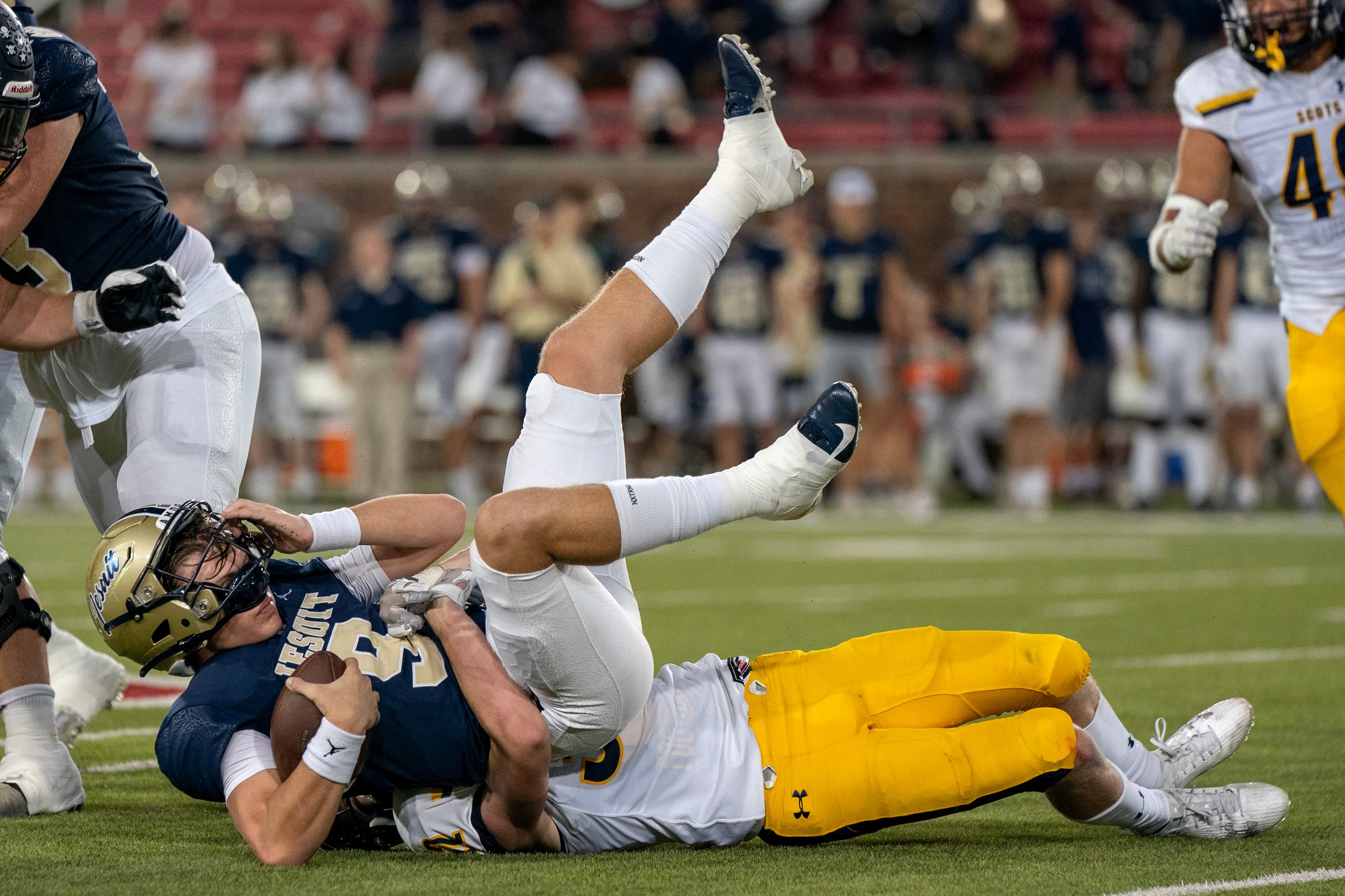 Jesuit junior quarterback Charlie Peters (9) is sacked by Highland Park senior linebacker...