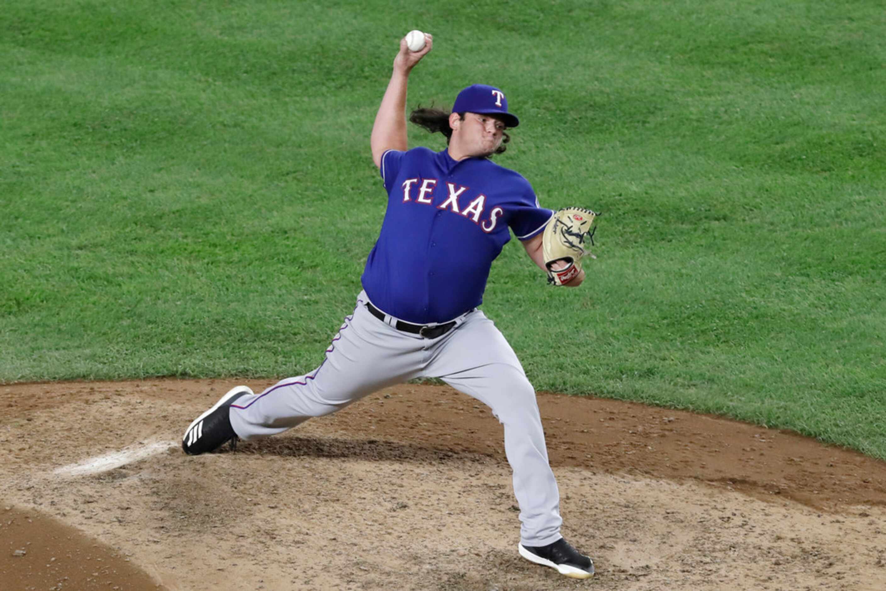 Texas Rangers relief pitcher Ian Gibaut winds up during the seventh inning of the team's...