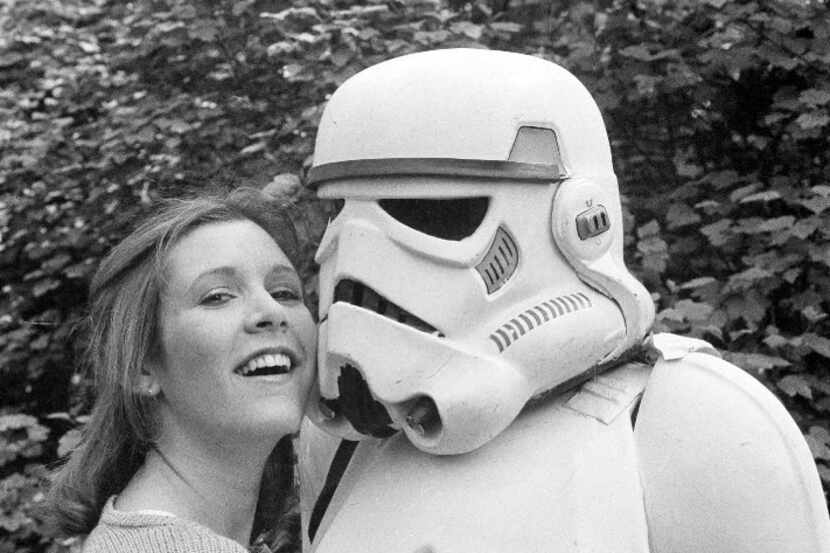 In this May 23, 1980, file photo, actress Carrie Fisher hugs a person dressed as a...
