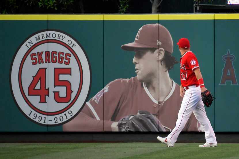Los Angeles Angels center fielder Mike Trout walks by a picture of Tyler Skaggs before a...