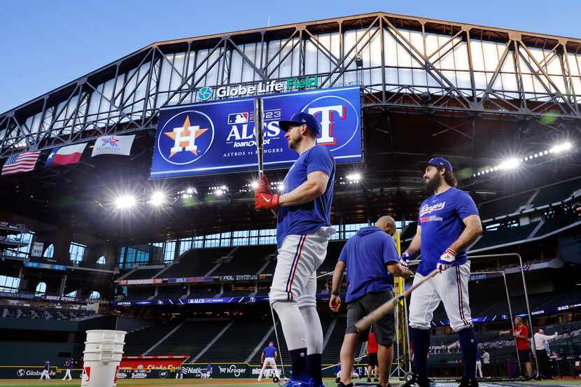 Texas Rangers designated hitter Mitch Garver (left) and catcher Austin Hedges warm up before...