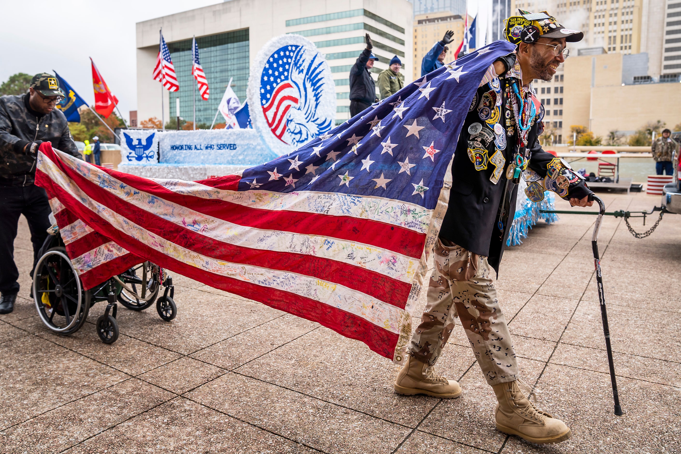 Rev. Mark ÒPinmanÓ Perez holds a flag as he passes City Hall during The Greater Dallas...