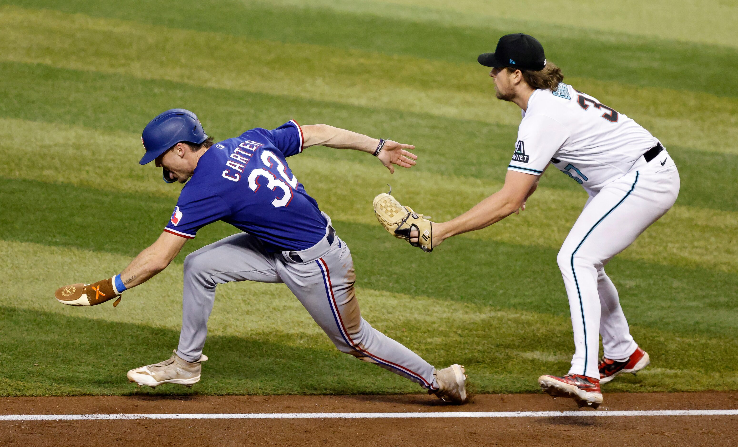 Arizona Diamondbacks relief pitcher Kevin Ginkel, left, tags out Texas Rangers Evan Carter,...