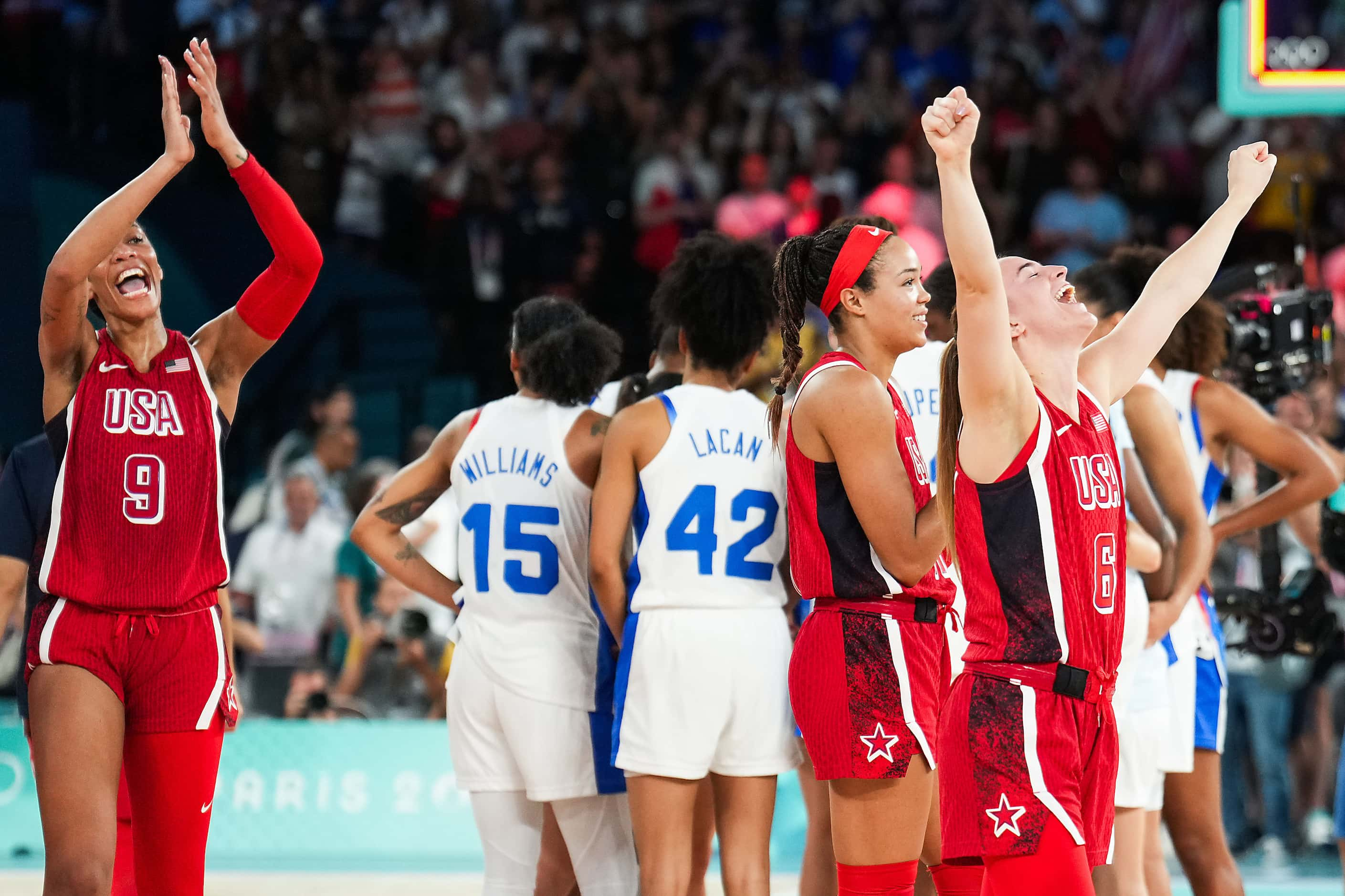 Sabrina Ionescu (6) and A'Ja Wilson (9) of the United States celebrate after a victory over...