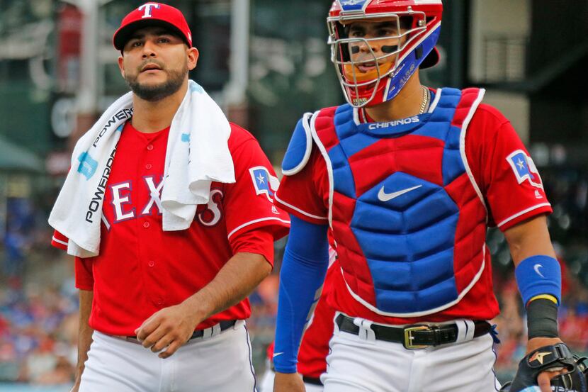 Texas Rangers starting pitcher Martin Perez (33) and catcher Robinson Chirinos (61) are...
