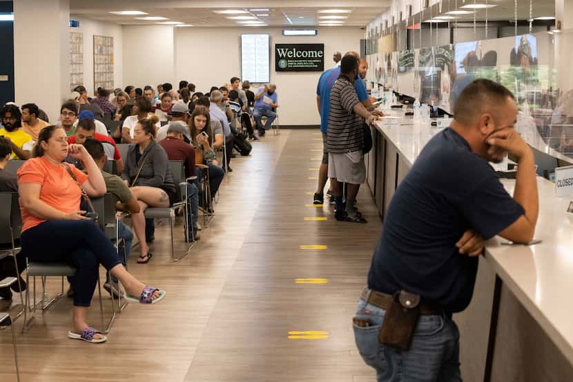 People waited for their number to be called at the Dallas County Tax Office in the Dallas...