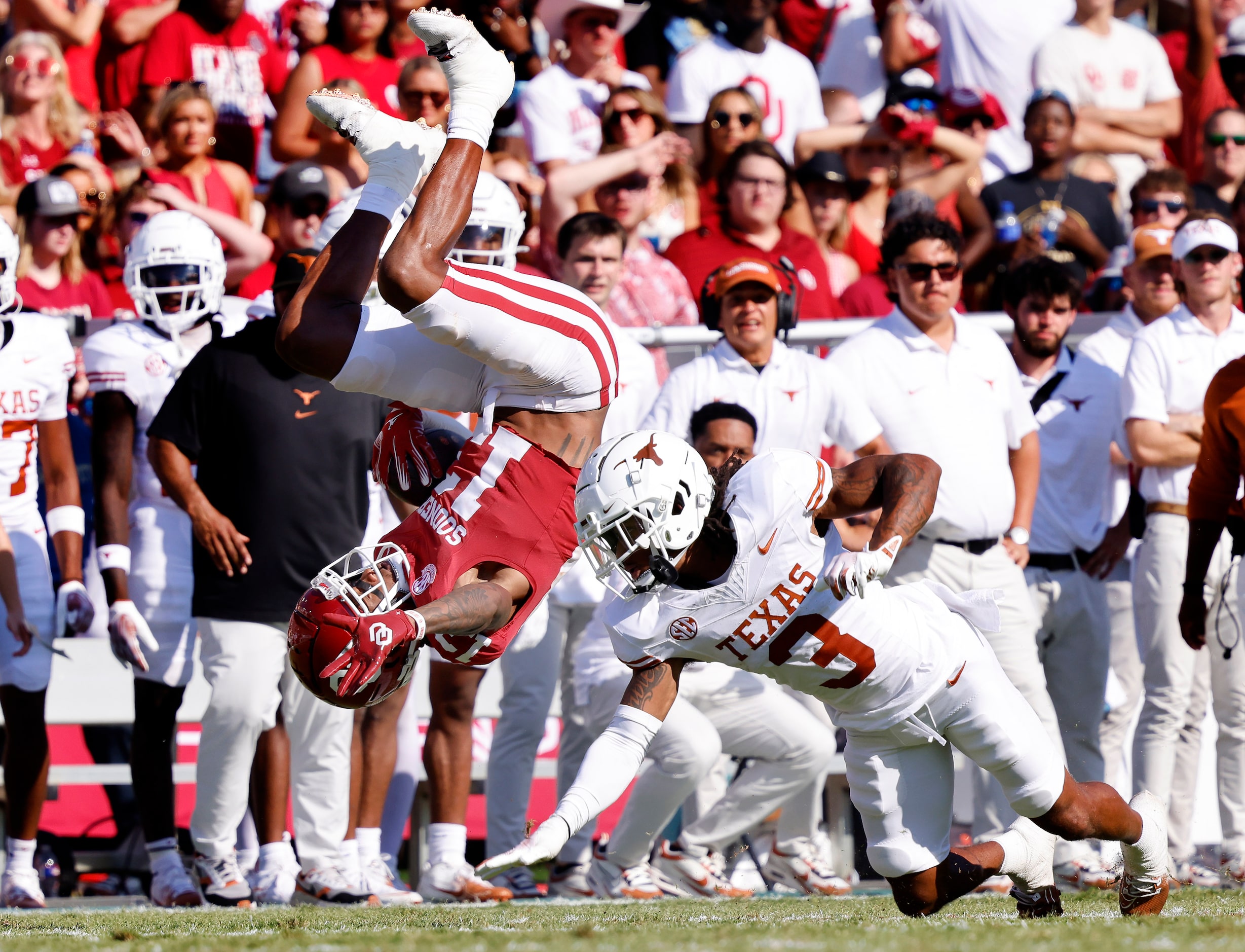 Oklahoma Sooners wide receiver J.J. Hester (13) is upended by Texas Longhorns defensive back...