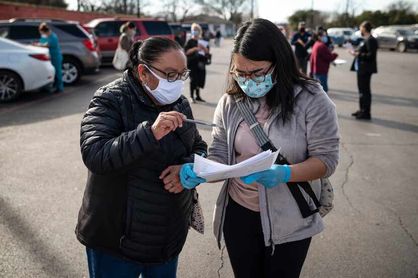 Maria Hernandez, 68, works with registered nurse Ruth Olvera, right, as she helps to...