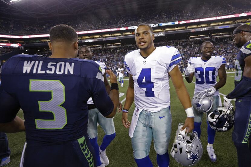 Dallas Cowboys quarterback Dak Prescott (4) talks with Seattle Seahawks quarterback Russell...