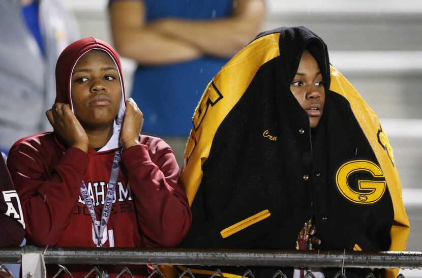 Garland's Nesha Green, 17, (left) and Ceville Cooper, 17, attempt to stay dry during a high...