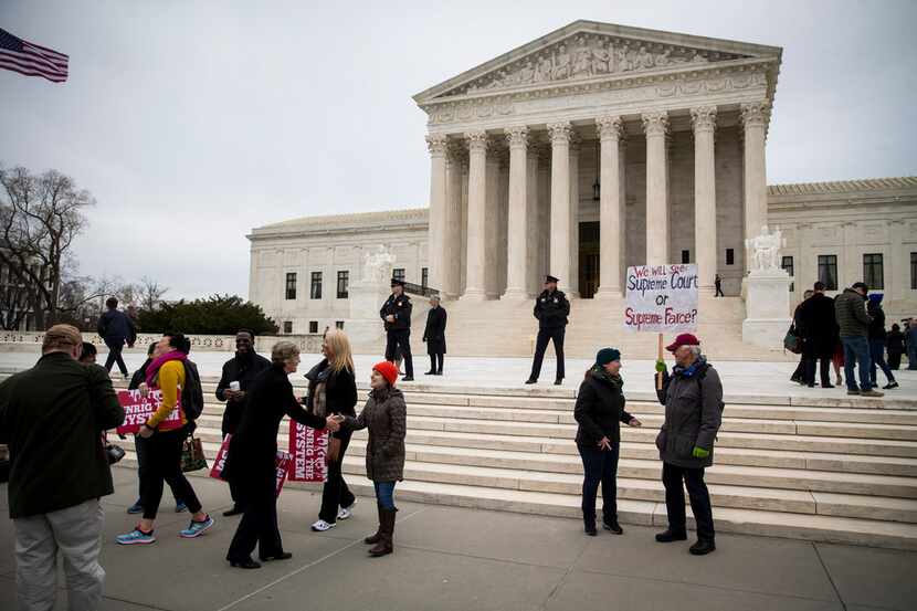 People gather outside of the Supreme Court in Washington, Feb. 26, 2018. The Supreme Court...