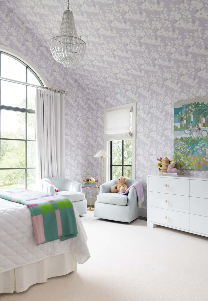 A bedroom has the same lilac wallpaper on the walls and ceiling.