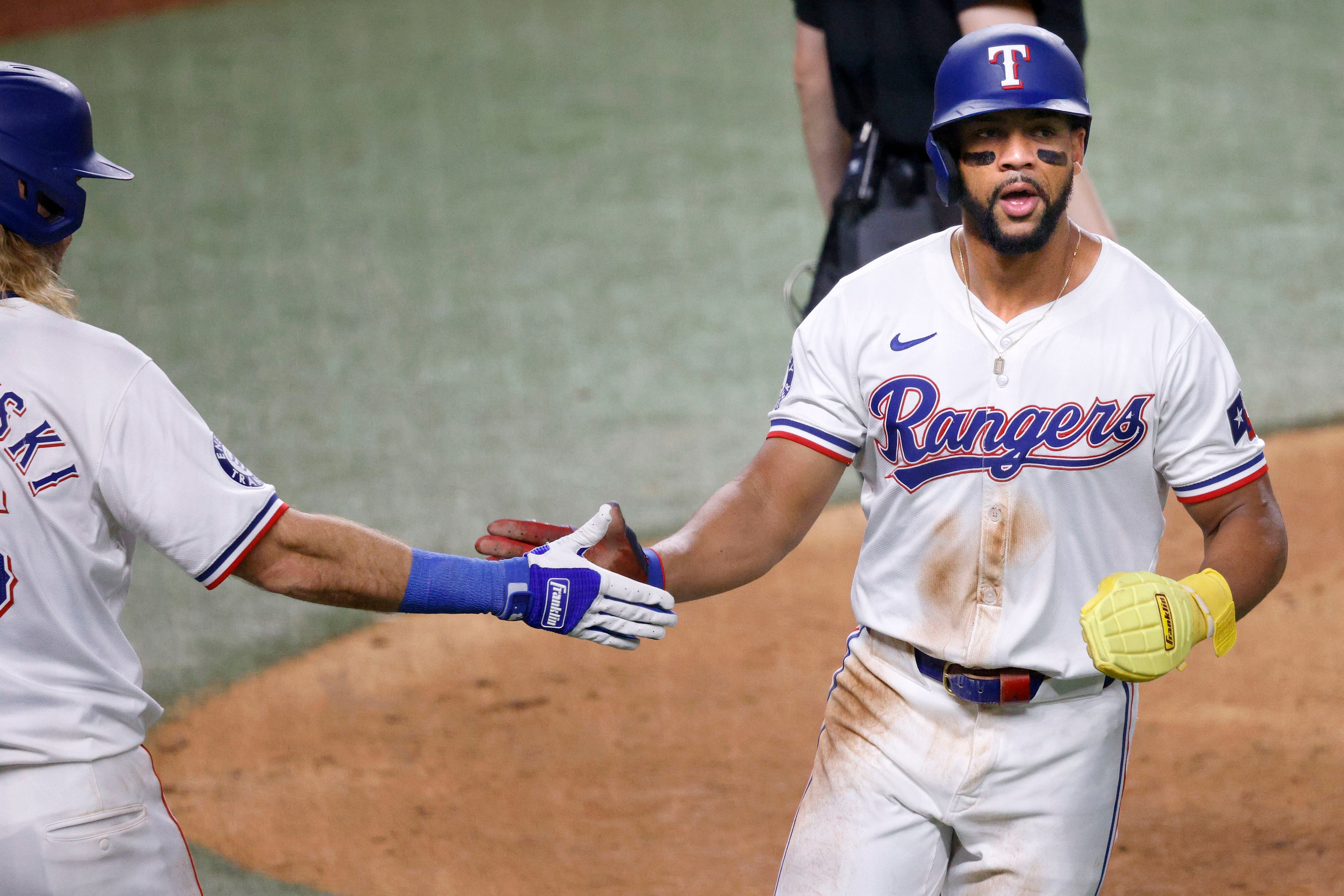 Texas Rangers outfielder Leody Taveras (3), right, gets a high-five from his teammate Travis...