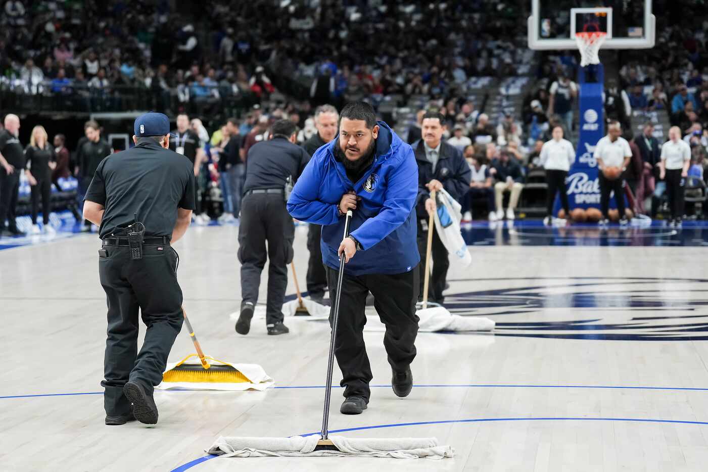 Arena workers wipe down the floor during a delay to the start of an NBA basketball game...