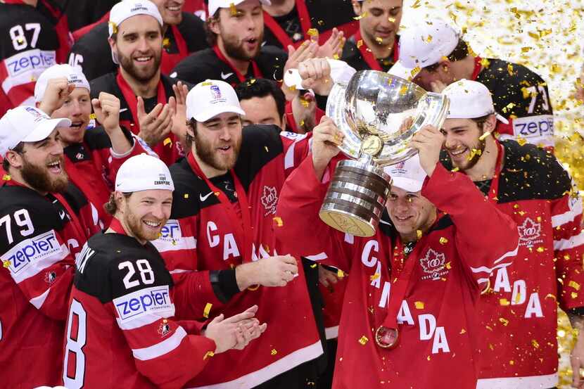 Forward Jason Spezza (R) of Canada raises the trophy of the IIHF Ice Hockey World...