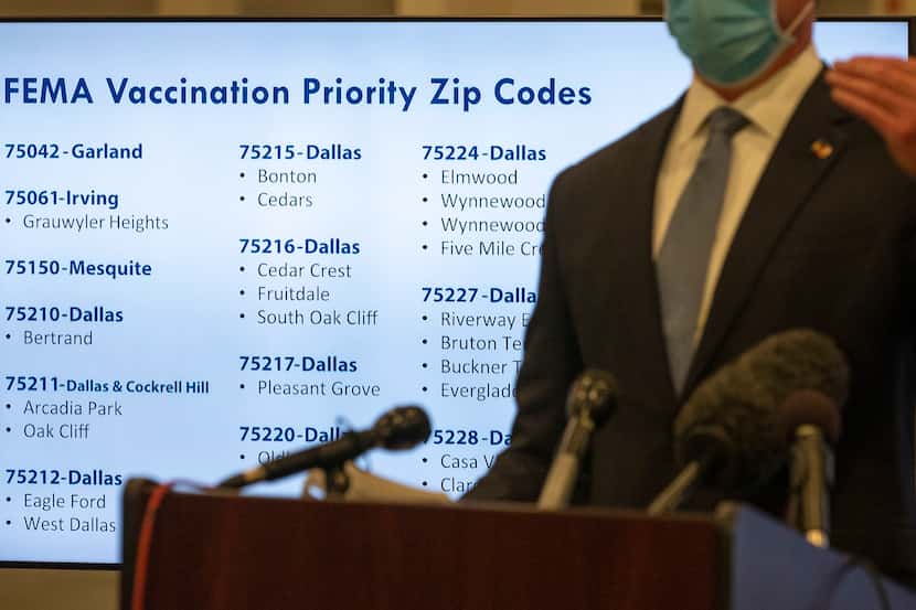A monitor displays vaccination priority zip codes for COVID-19 as Dallas County Judge Clay...