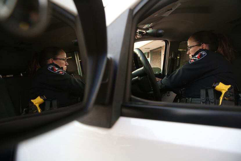 DWI police officer Stacie Brown logs on to her computer inside her squad car at the...