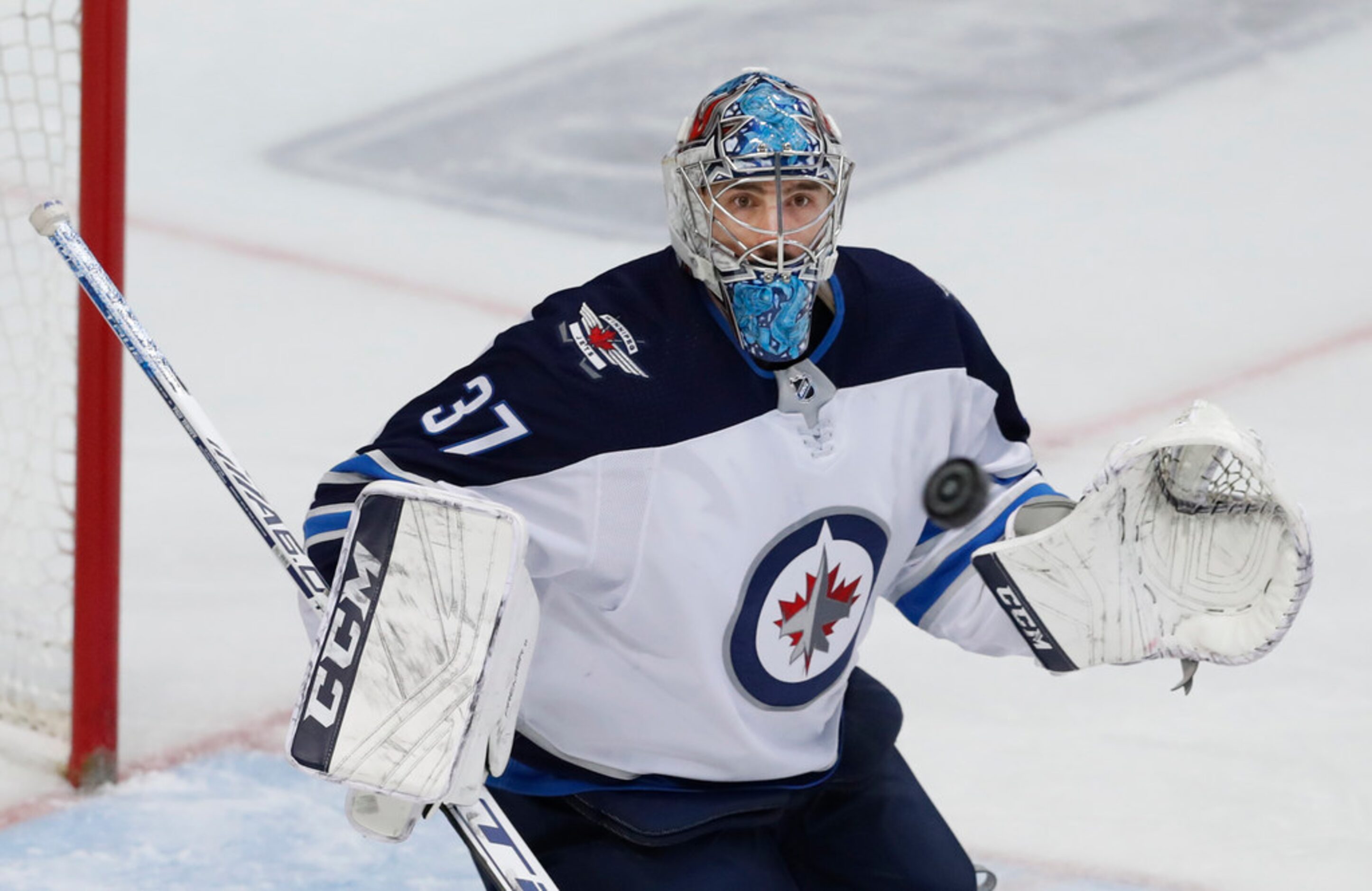 Winnipeg Jets goaltender Connor Hellebuyck (37) watches the shot during the first period of...