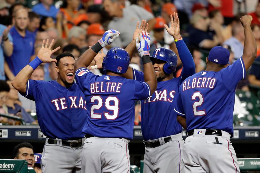Texas Rangers' Adrian Beltre (29) is congratulated by Carlos Gomez, left, Elvis Andrus and...