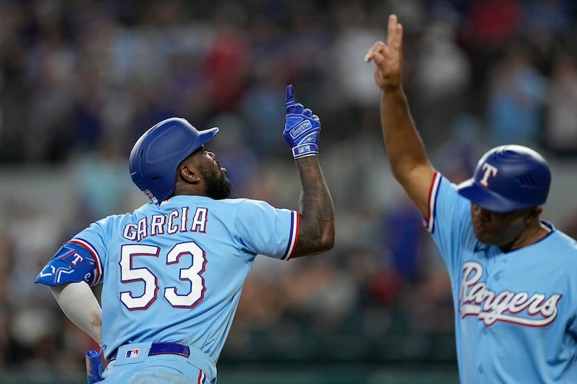 Texas Rangers' Adolis Garcia (53) and third base coach Tony Beasley, right, celebrate after...