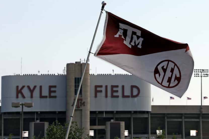 Texas A&M flags bearing the SEC logo bristle in the steady breeze outside Kyle Field before...