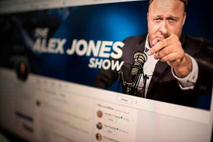 A computer screen displays the Twitter account of far-right conspiracy theorist Alex Jones....