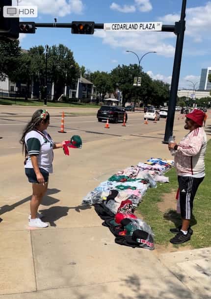 Merchandise vendor José Hernández talks with a customer outside AT&T Stadium prior to the...