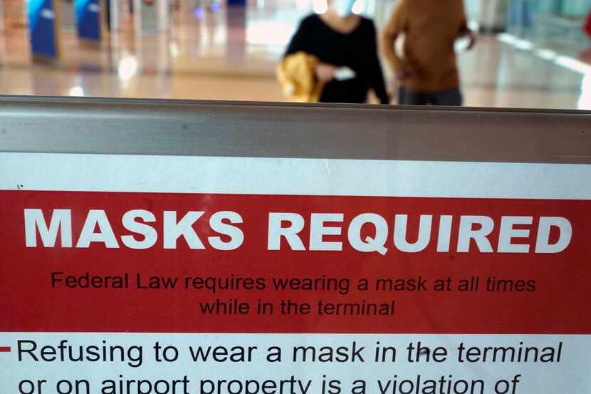 To prevent the spread of Covid-19, a sign directs travelers to wear masks at Dallas' Love...