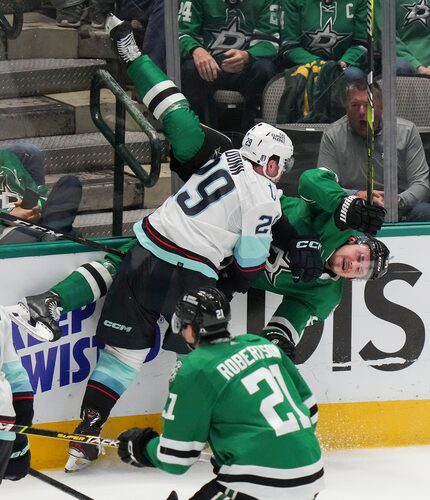 Dallas Stars center Roope Hintz (24) is checked byt Seattle Kraken defenseman Vince Dunn...