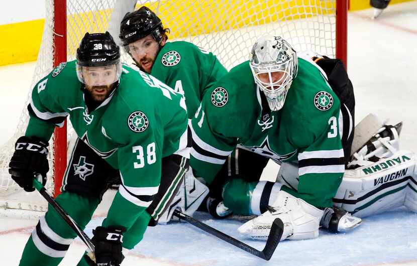 Dallas Stars defenseman Jason Demers (4) ends up in the goal trying to help goalie Antti...