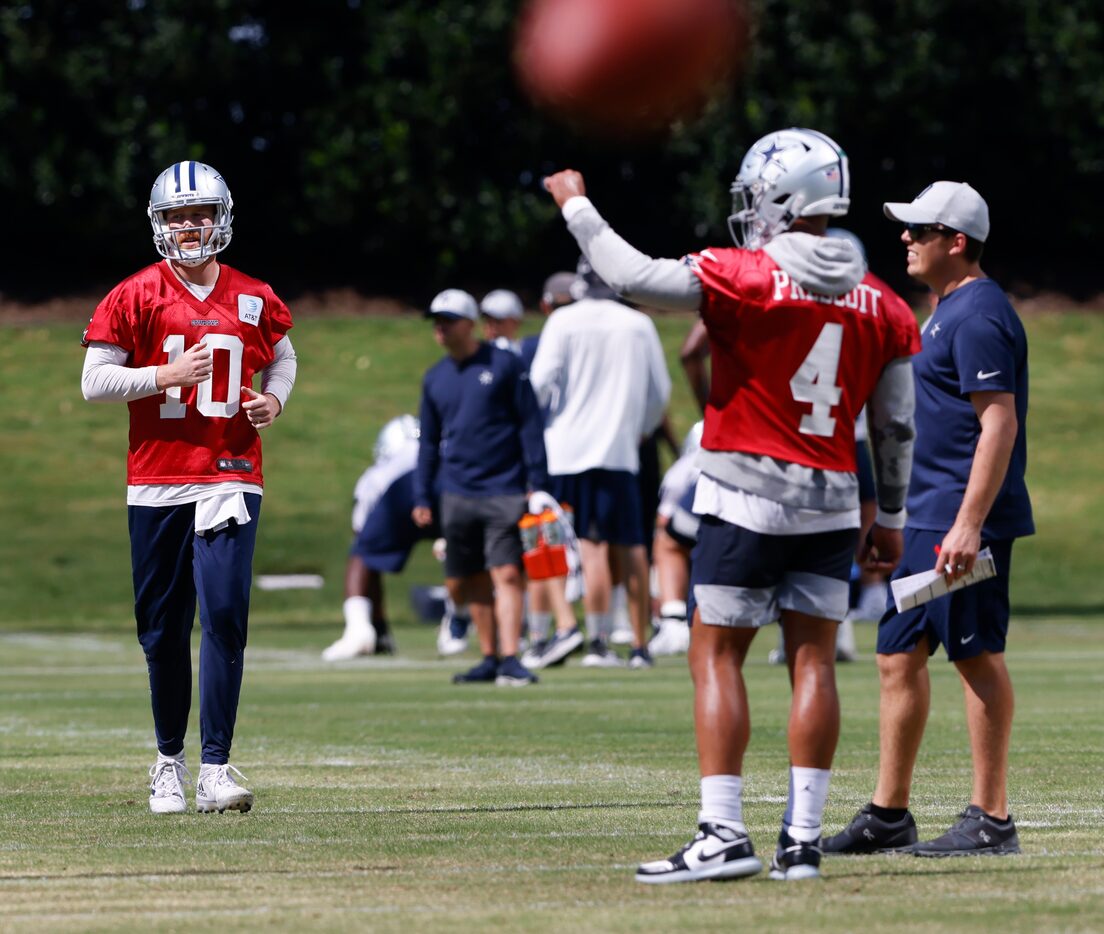 Dallas Cowboys quarterback Cooper Rush (10) runs to Dallas Cowboys quarterback Dak Prescott...