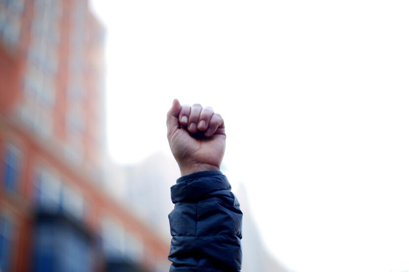 A man raises his fist at a makeshift memorial for victims of the Boston bombings at the...