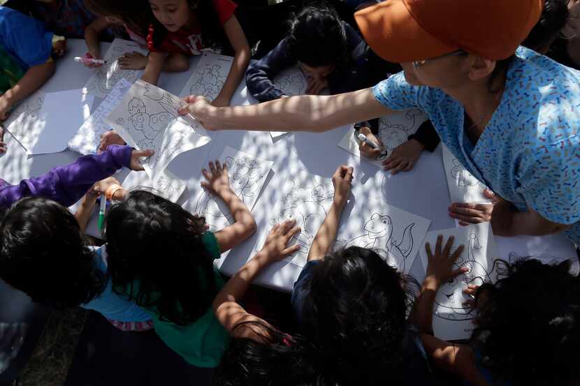 Detainees color and draw at a U.S. Customs and Border Protection processing facility,...