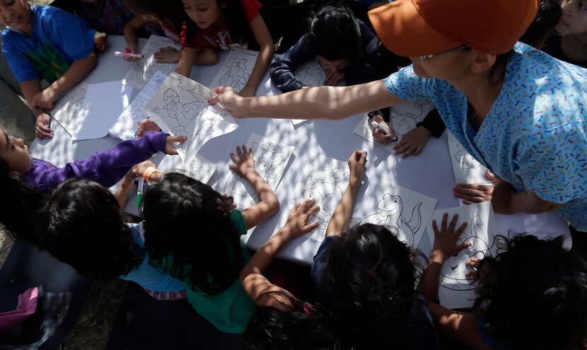 Detainees color and draw at a U.S. Customs and Border Protection processing facility,...