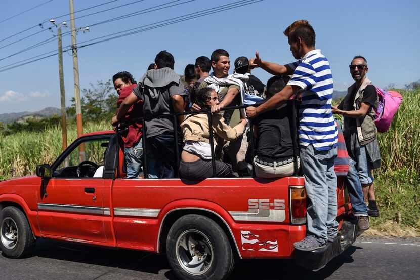 Honduran migrants heading to the United States with a second caravan travel aboard a pick-up...