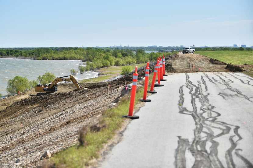 A long gap was carved away from the top ridge of the Lewisville Lake dam at the site of a...