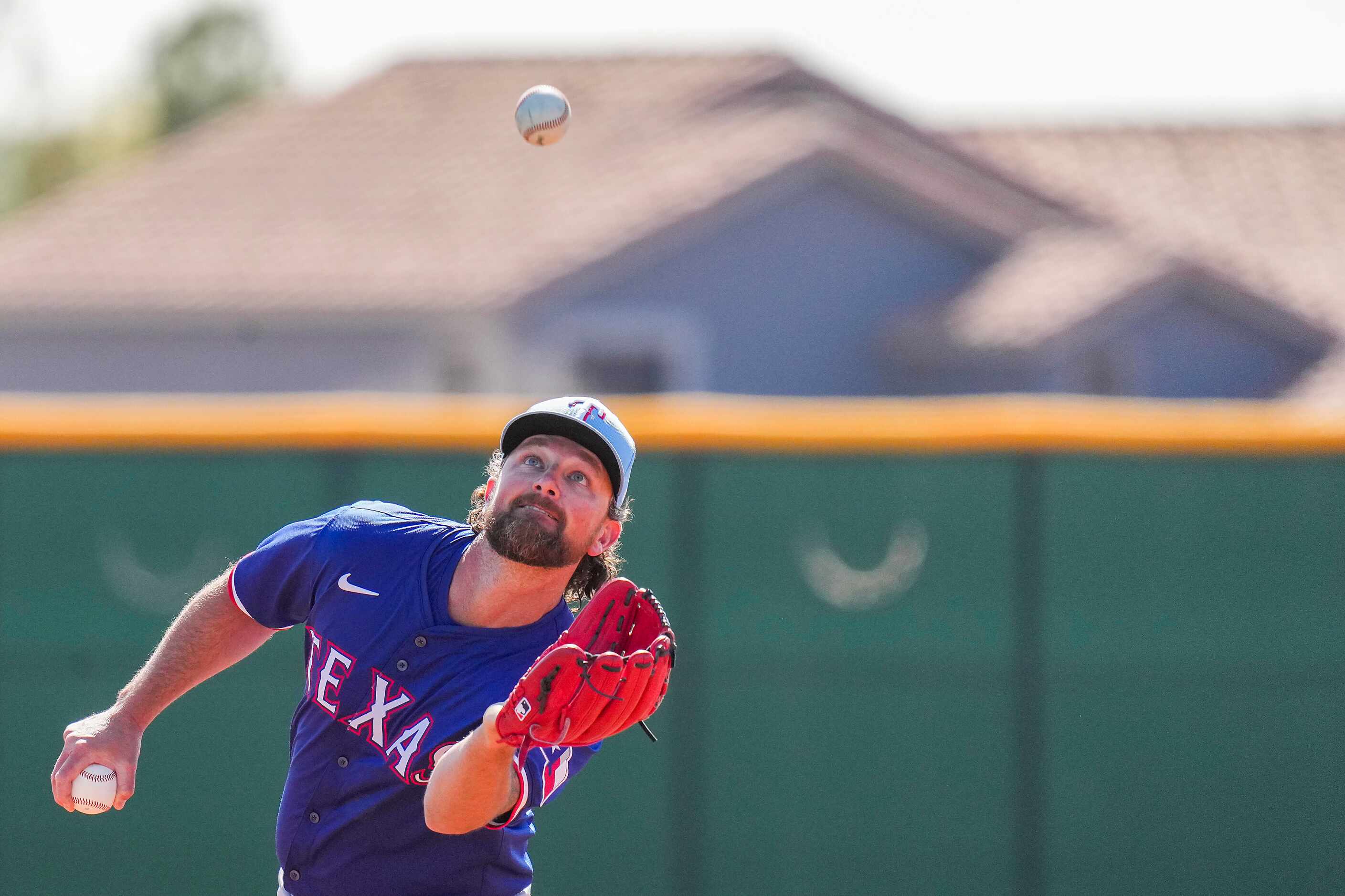 Texas Rangers pitcher Kirby Yates catches a popup in a fielding drill during a spring...