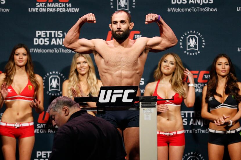 Johny Hendricks, of Dallas, flexes while being weighed during the weigh-ins for UFC 185 at...
