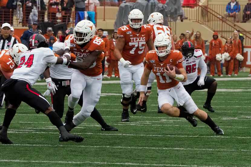 Texas quarterback Sam Ehlinger (11) runs the ball during the first half of an NCAA college...