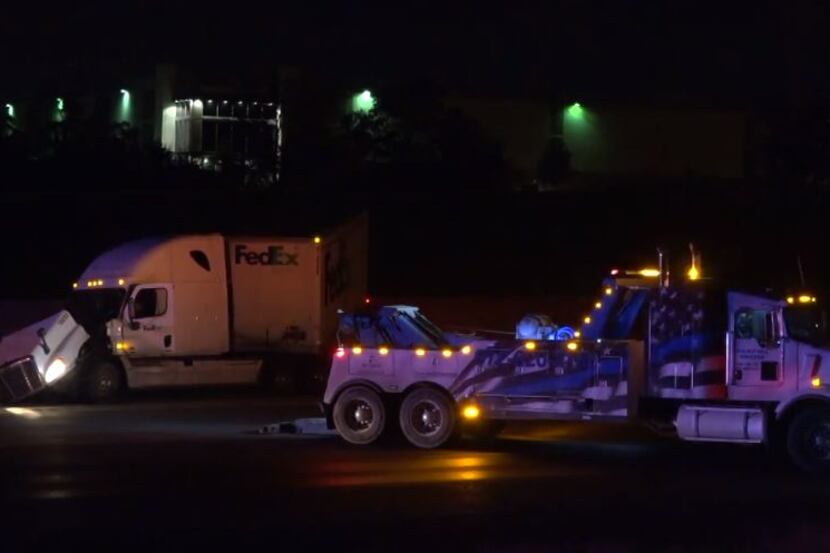 A tow truck prepares to haul off a FedEx truck that crashed on an icy Interstate 20 on...