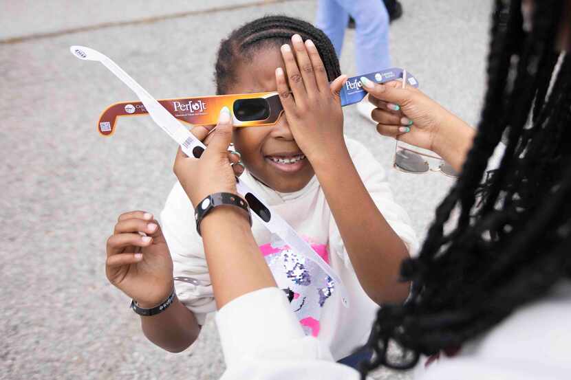 Avery Phillip, 5, of Frisco tests her eclipse glasses at the Great North American Eclipse...