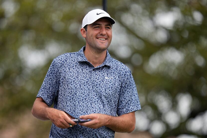 Scottie Scheffler smiles at the first tee as he waits to hit during the first round of the...