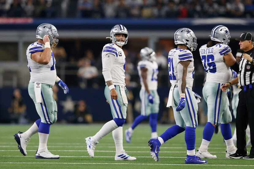 Dallas Cowboys quarterback Dak Prescott (4) looks back as he walks to the bench after...