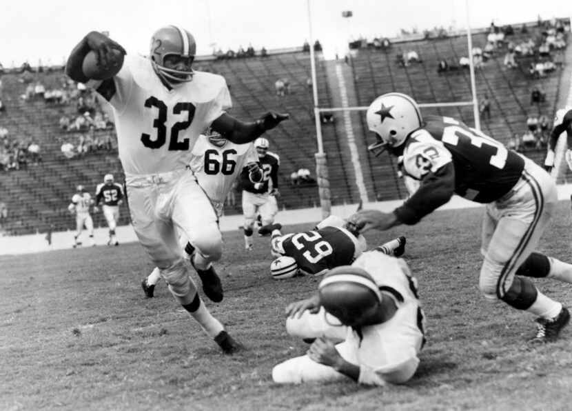 Jim Brown (32), fullback of the Cleveland Browns, appears at the Cotton Bowl, picking up a...