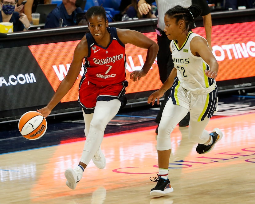 Washington Mystics guard Ariel Atkins (7) drives past Dallas Wings guard Tyasha Harris (52)...