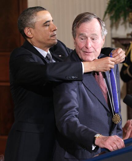 President Barack Obama presents former President George H.W. Bush the 2010 Medal of Freedom...